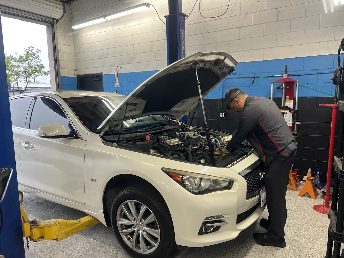 Rev It Auto Repair technician working on a customer's INFINITI